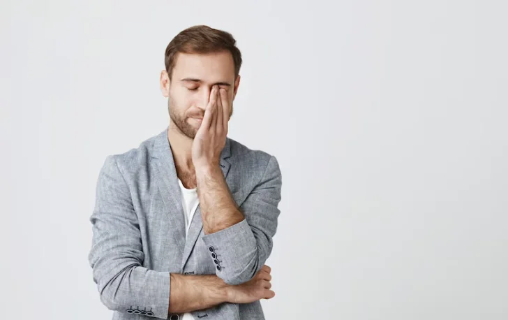 мужчина с неврастенией держится за голвоу